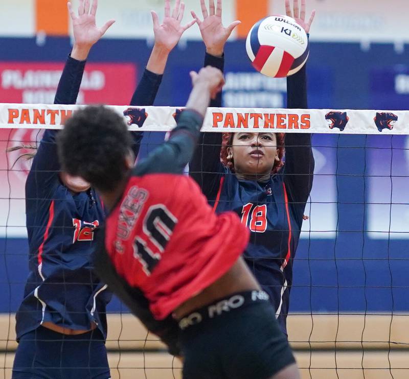 Oswego’s Maya Norlin (18) blocks a kill attempt by Yorkville's Joelle Pye-Blacknard (10) during a volleyball match at Oswego High School on Thursday, Sept. 14, 2023.