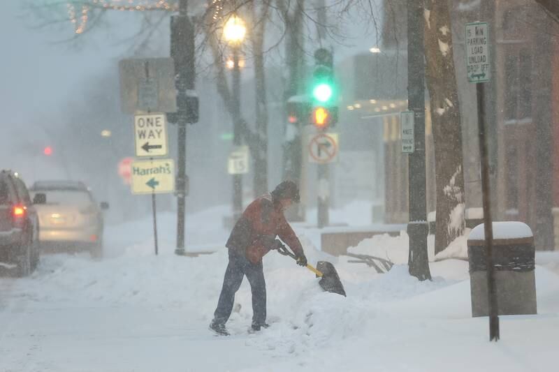A man clears snow outside businesses along North Chicago Street. Wednesday, Feb. 2, 2022 in Joliet.
