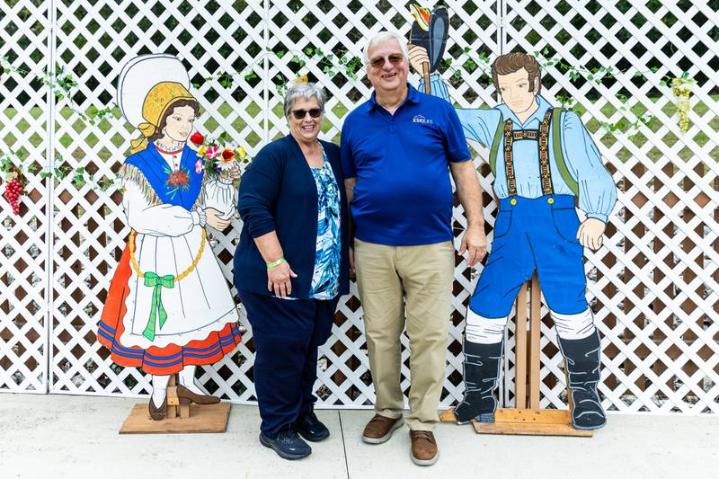 Eveleth, MN residents Connie and Tony Menart pose for a photo by the Slovenian Grape Harvest Festival display on Sept. 29, 2024.