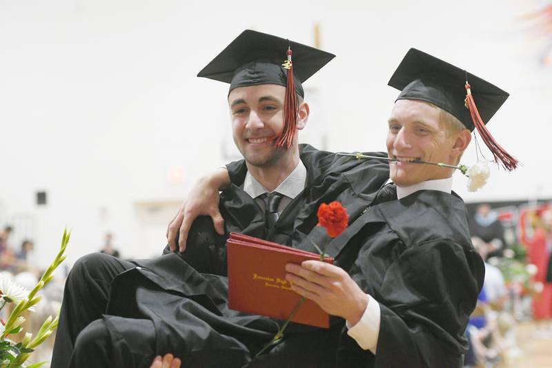 Cole Becker holds classmate Logan Dyson as they strike a pose following Forreston High School commencement on Sunday. Fifty-five seniors received diplomas during the afternoon event.