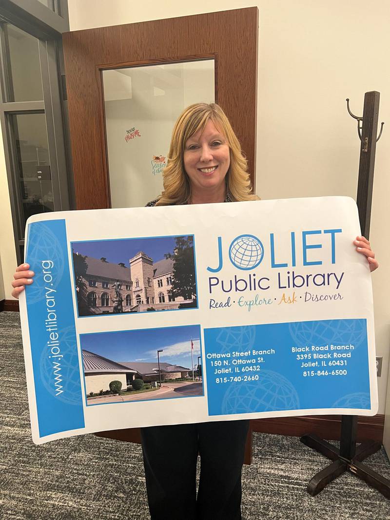 Executive Director of the Joliet Public Library Megan Millen posed with an oversized Joliet Public Library card for a recent sign up promotion.
