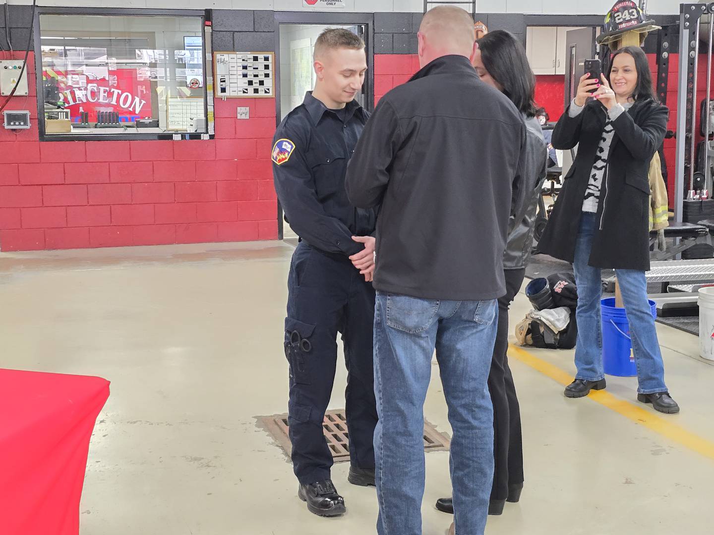Newly sworn-in Princeton firefighter/EMT Tony Maciczak's badge is pinned at a ceremony Monday, April 7, 2025, by his parents Tony and Donna at the Princeton Fire Department.