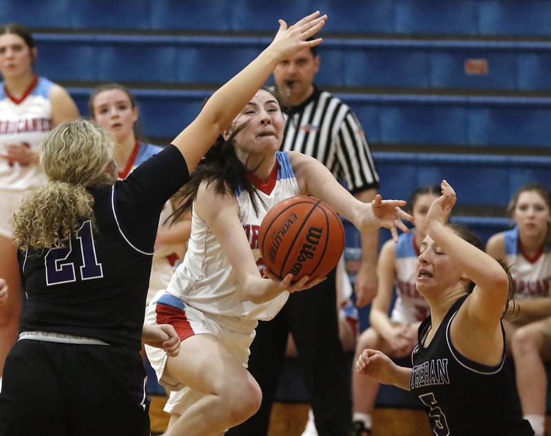 Marian Central's Kiara Kelly shoots the ball between Rockford Lutheran's Stella Henry (left) and Addie Richard (right) during a non-conference girls basketball game Monday, Dec. 12, 2022, between Marian Central and Rockford Lutheran at Marian Central Catholic High School, in Woodstock.