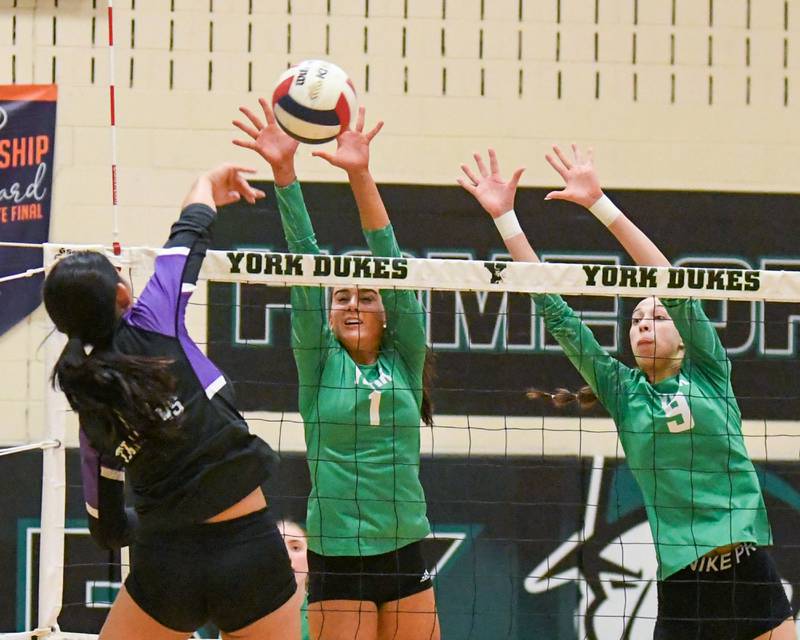 York's Amalia Toliopoulos (1) and teammate Lilly Roach (9) block the ball from Downers Grove North's Nicole Liu (11) during the game on Tuesday Oct. 22, 2024, held at York High School in Elmhurst.