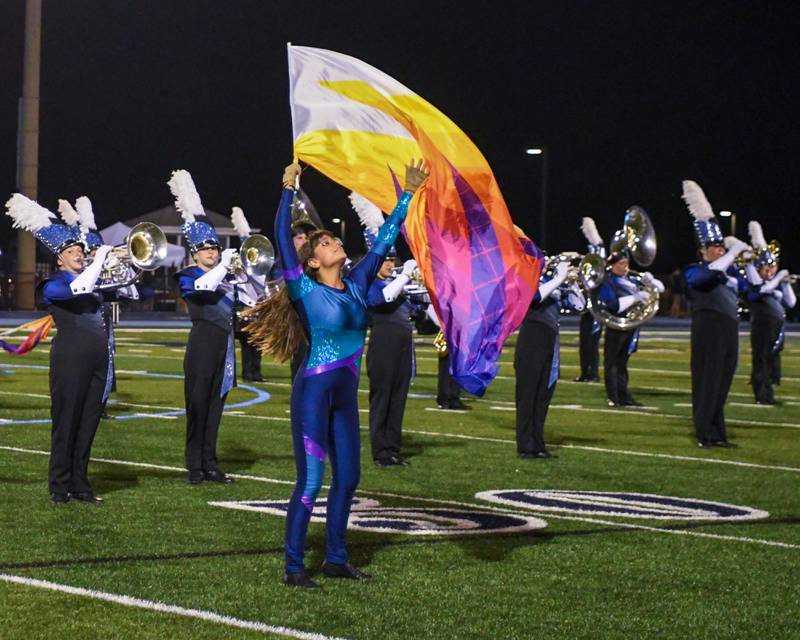 Downers Grove South color guard member Josephine Sender preforms withs the Downers Grove South band on Saturday Oct. 5, 2024, during the Downers Grove South Marching Mustangs Music Bowl held at the football field at Downers Grove South High School.