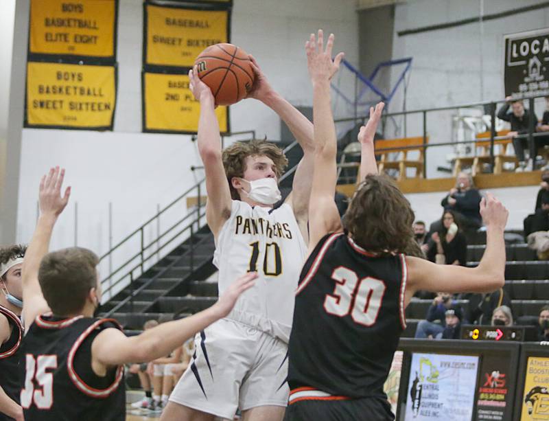 Putnam County's Austin Mattingly, (10) splits Roanoke-Benson defenders Chase Martin, (30) and teammate Jackson Beer, (35) to score a bucket Marquette’s (15) Tommy Durdan, runs in the lane to score a basket over Dwight’s Connor Telford, (3) at the Tri-County Conference Tournament on Tuesday Jan. 25, 2022 in Granville.