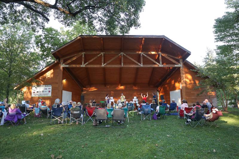 Dozens of residents line the band shell at Goold Park to watch the GreenRoom Improv show hosted by the Morris Library on Friday, Aug. 11, 2023 in Morris.