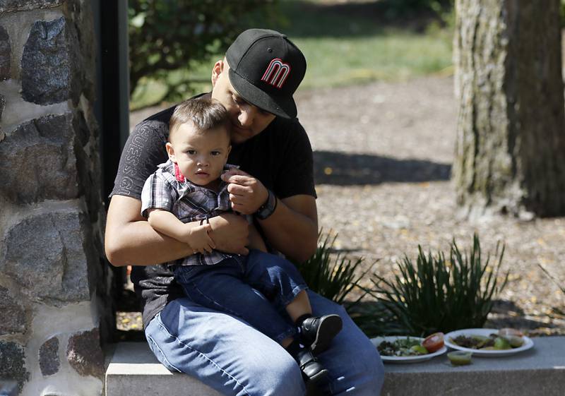 Alberto Ramirez, gives his som Luca, a bight of a taco  on Sunday, Sept. 14, 2025, during the annual Hispanic Connections Mexican Independence Day Celebration in the Historic Woodstock Square. The celebration featured music, food and culture.