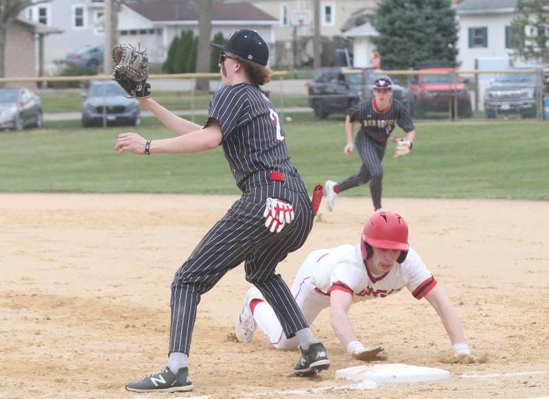 Hall's Izzaq Zrust waits for a throw back to first base as Streator's Colin Byers slides back into the bag on Wednesday, March 13, 2024 at Kirby Park in Spring Valley.