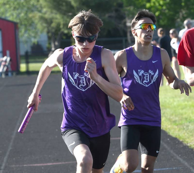 Dixon's Daniel Ramirez hands the baton to Ethan Carter in the final exchange of the 4x800 relay at the Big Northern Conference Meet at Stillman Valley on Thursday, May 14, 2026.