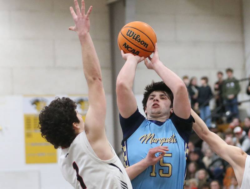 Marquette's Alec Novotney takes a jump shot over Woodland's Brezdyn Simons during the Tri-County Conference Tournament championship on Friday, Jan. 30, 2026 at Putnam County High School.