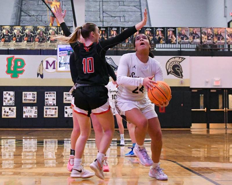 Sycamore's Monroe McGhee, right, gets around Yorkville's Bella Phillips (10) and makes a basket during the first quarter on Thursday Dec. 21, 2023, held at Sycamore High School.