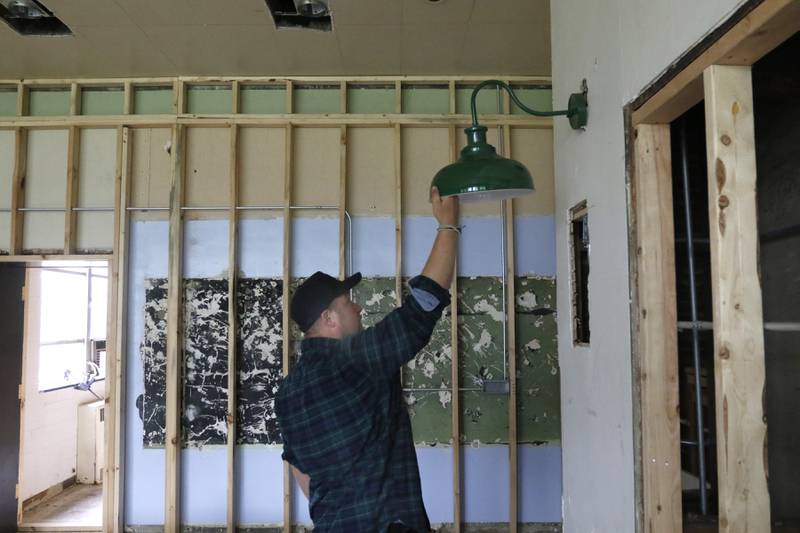 Brent Hollenberg shows a light fixture that he plans to use in the Ridgefield schoolhouse, at 8617 Ridgefield Road, near Crystal Lake, on Wednesday, May 21, 2025. Hollenberg plans to turn the schoolhouse into a six-unit Airbnb. The building was last the home of the McHenry County Jewish Congregation.