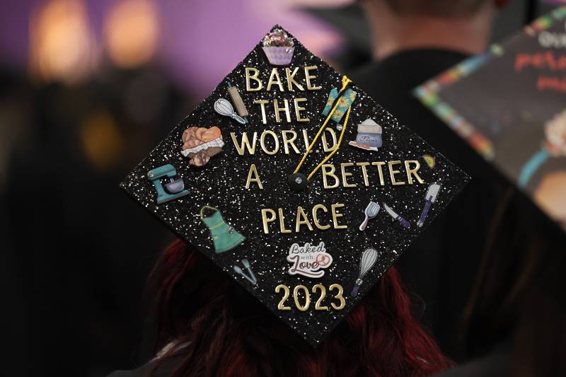 A culinary graduate customizes their hat at the Joliet Junior College Commencement Ceremony on Friday, May 19, 2023, in Joliet.