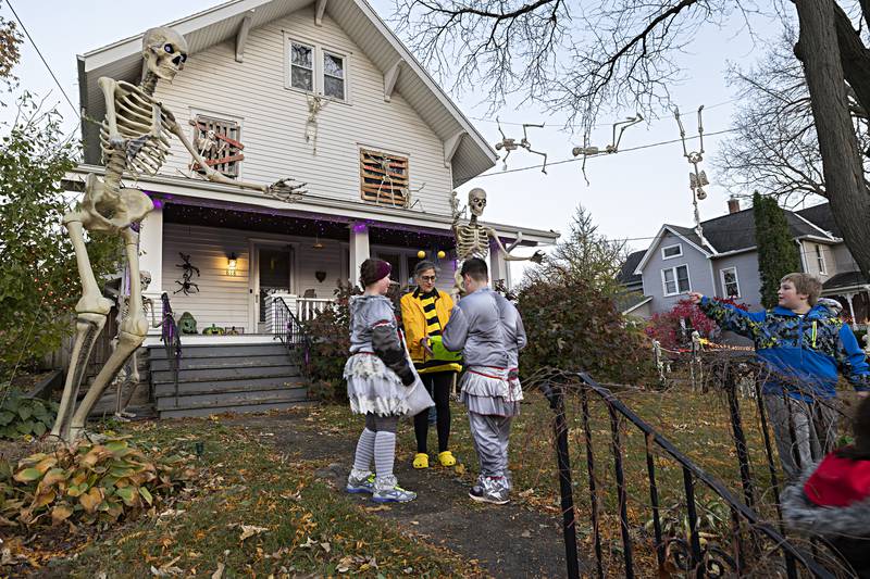 Laura Meyer hands out candy in front of a well-decorated house in Dixon for trick or treating Tuesday, Oct. 31, 2023