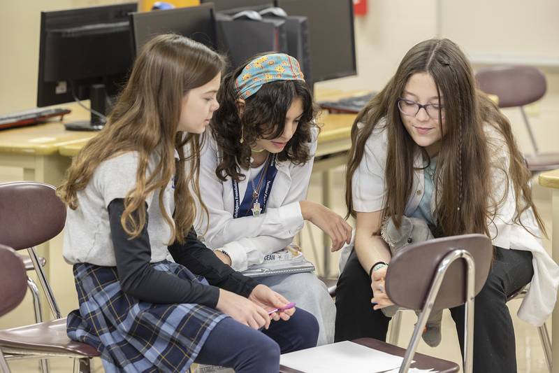 Sophia Gutierrez (left), 6th grader, Joslyn Moore, 8th grader and Emily Dorathy, 8th grader, collaborate on a project together Monday, Jan. 29, 2024 at St. Mary’s School in Sterling.