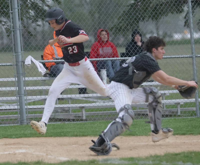 Henry-Senachwine's Landon Harbinson leaps onto home plate as the throw comes in late to Woodland catcher Brezdyn Simons on Tuesday, May 12, 2026 at Woodland High School.