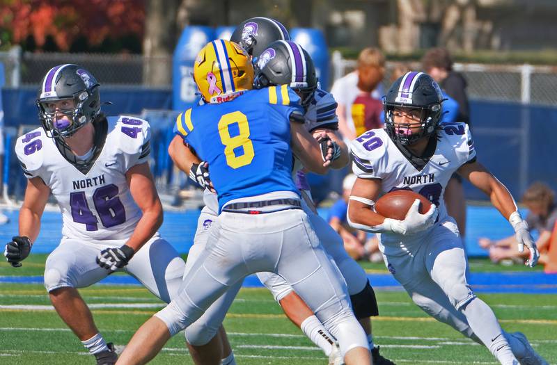 Downers Grove North running back Noah Battle (20) makes a cut to follow his blockers during a game against Lyons Township on Oct. 22, 2022 at Lyons Township High School in LaGrange.