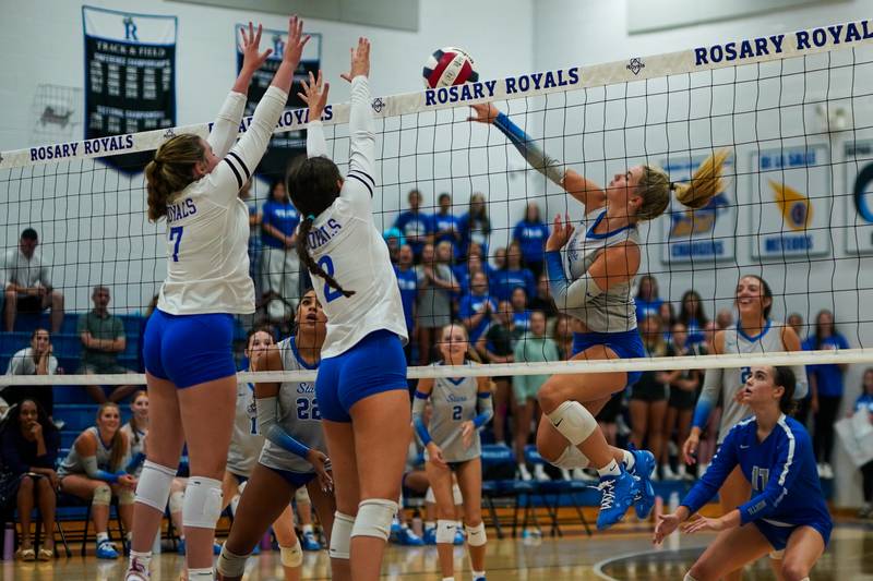 St. Charles North's Amber Czerniak (right) goes up for a kill attempt against Rosary’s Emily Toepper (7) and Charlotte Blankenheim (2) during a volleyball game at Rosary High School in Aurora on Monday, Aug 25, 2025.