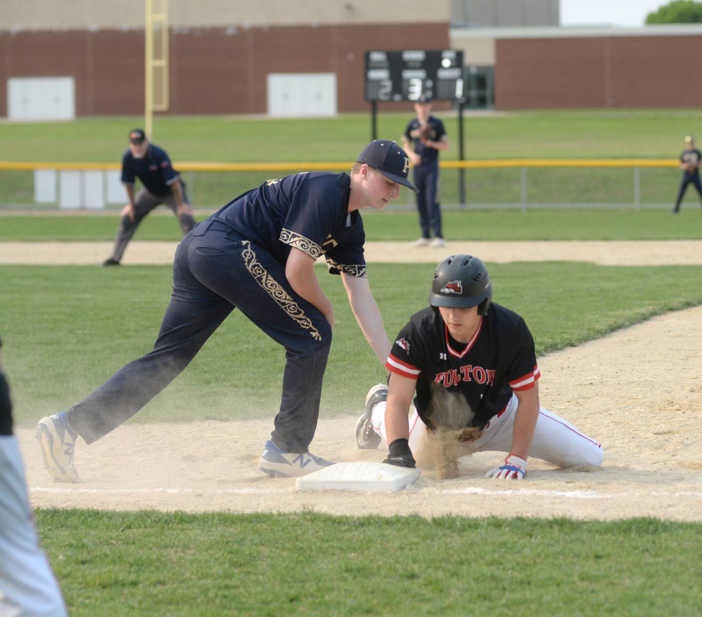 Fulton's Aj Boardman dives safely back to first as Polo's Landen Brooks tags him during regional action in Forreston on Wednesday, May 17.