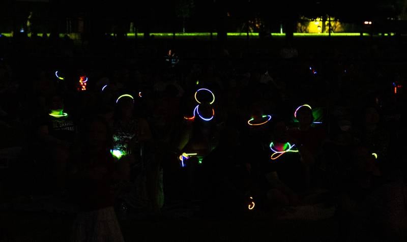 Spectators adorned with glow sticks watch the “July 4th Fireworks” at Langum Park in St. Charles on Friday, July 4, 2025.