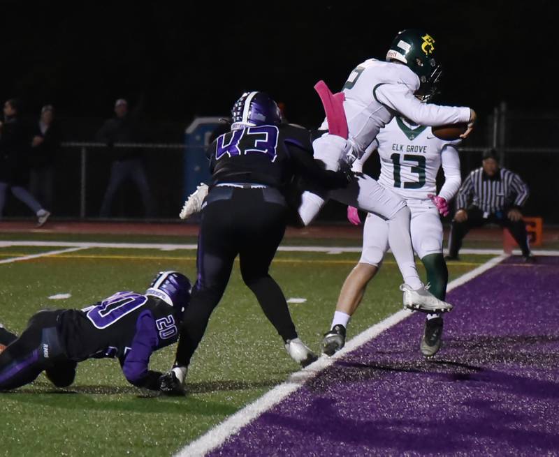 Elk Grove quarterback Mitchell Janzak leaps over the goal line for a touchdown against Rolling Meadows in a football game in Rolling Meadows on Friday, October 7, 2022.