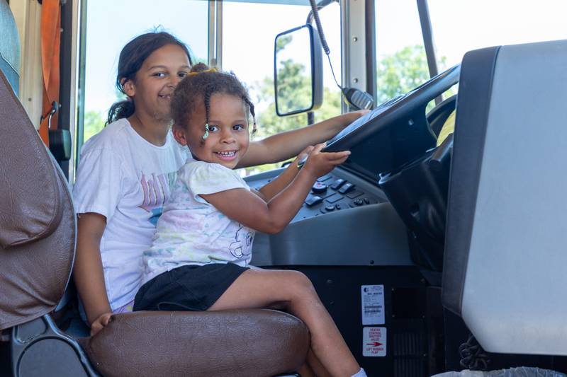 (left to right) Maleigha & Kamiyah Kundert sit inside school bus at the Touch a Truck event on Saturday, June 28, 2025 at Centennial Park in Peru.
