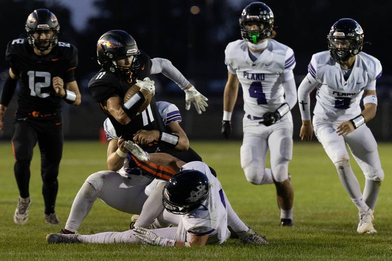 Sandwich's Nick Michalek leans forward for more yardage while being brought down by a Plano tackler during Friday's game in Sandwich.