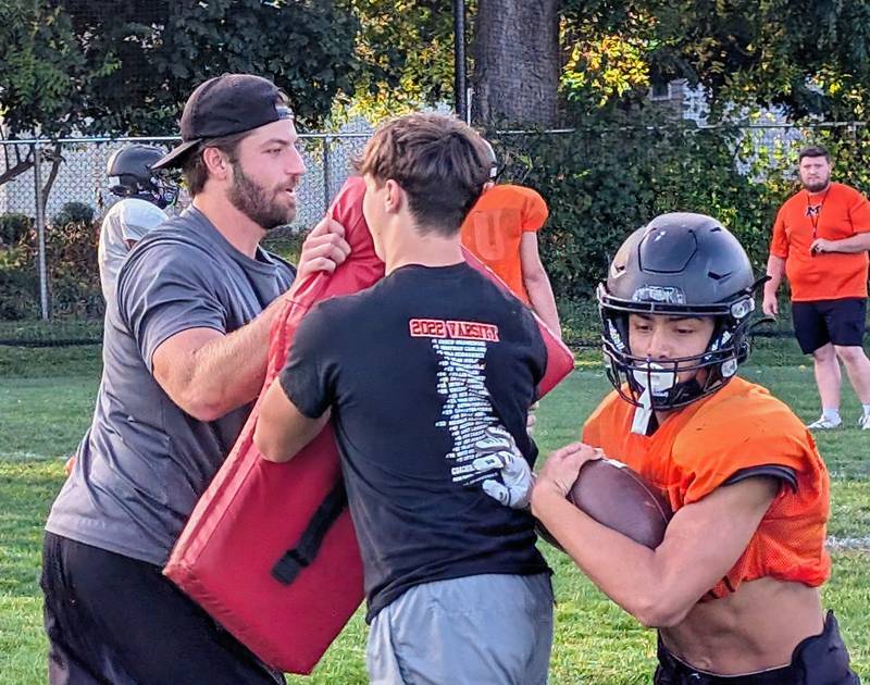 McHenry assistant football coach Derek Franzen (left) runs a drill during practice Tuesday, Sept. 30, 2025, at McCracken Field in McHenry. Franzen served in the U.S. Marine Corps from 2017-2021.