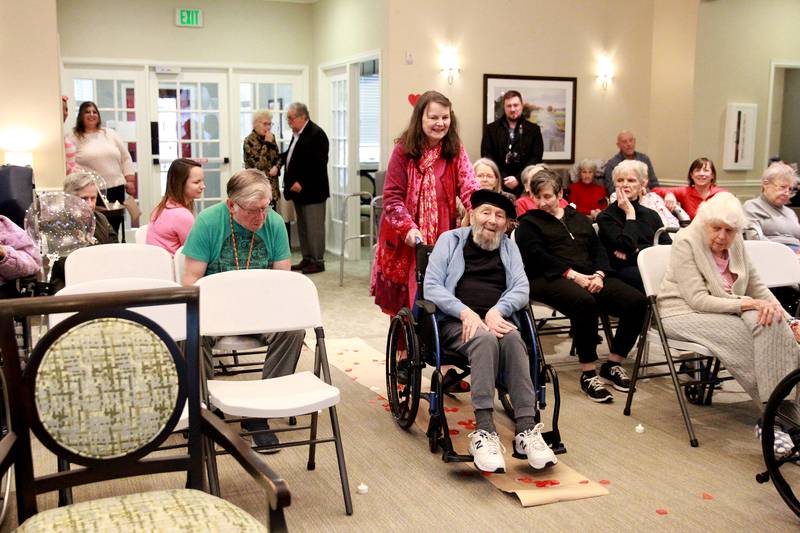 Marcia Whitney-Schenck and Robert Schenck, who have been married for 42 years, go down the aisle before renewing their wedding vows on Friday, Feb. 14, 2025 at Churchill Place, an Anthem Memory Care community in Glen Ellyn.
