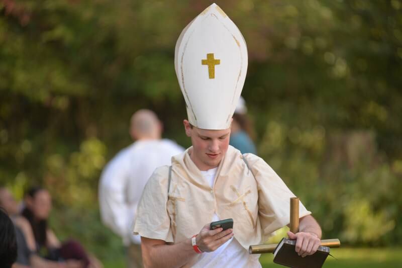 A costumed visitor to the Olde English Fair at Stronghold Camp & Retreat Center checks his cell phone  on Saturday, Oct. 5, 2024, during the Autumn on Parade festival in Oregon.