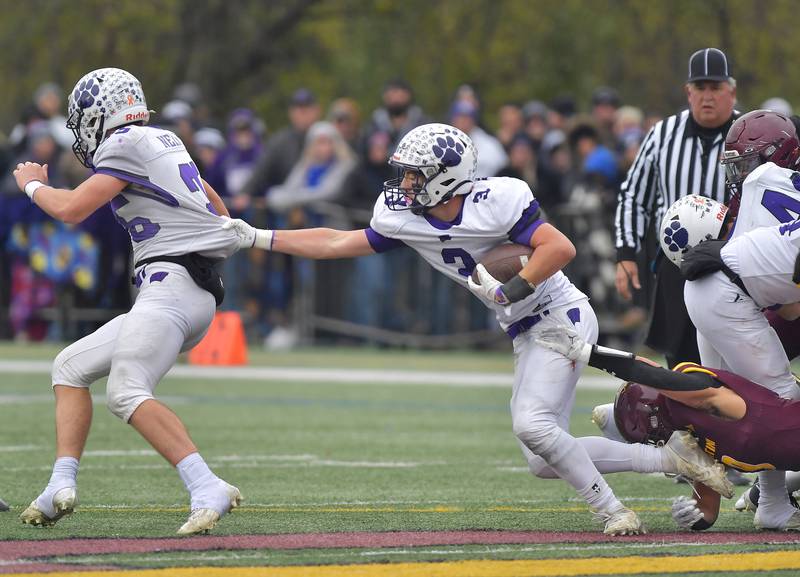 Wilmington's Ryan Kettman (3) tries to escape a Montini tackler by holding on to teammate Ryan Nelson (left) during a Class 3A semifinal game on November 23, 2024 at Montini Catholic High School in Lombard.