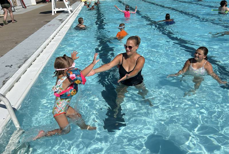 Stephanie Grobe gets ready to catch Kya Demus, 4, as she jumps into the Polo Pool on Monday, July 28, 2025. Grobe lives in Byron, but grew up in Polo and brought her kids to the pool to beat the heat.