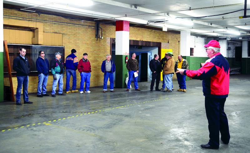 Mel Foster Co. Auctioneer D. Herb Burns (right) opens bidding Thursday morning for the Sterling Centers building at 301 W. Third St. in Sterling.
