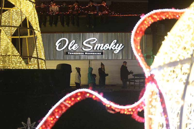 A family walks along the decorated concourse at the GLOW Holiday Festival at Slammers Stadium on Wednesday, Nov. 27, 2024 in Joliet.