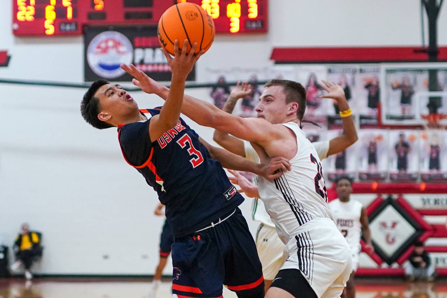 Yorkville's Taelor Clements (21) defends the post against a shot attempt by Oswego’s Ethan Vahl (3) during a hoops for hope basketball game at Yorkville High School on Saturday, Feb. 8, 2025.