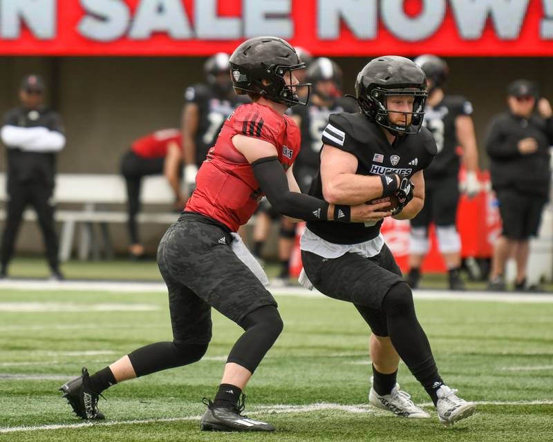 Northern Illinois University's Josh Holst, left, hands the ball off to Justin Lynch during a scrimmage on Saturday April 27, 2024, held at Huskie Stadium in DeKalb.