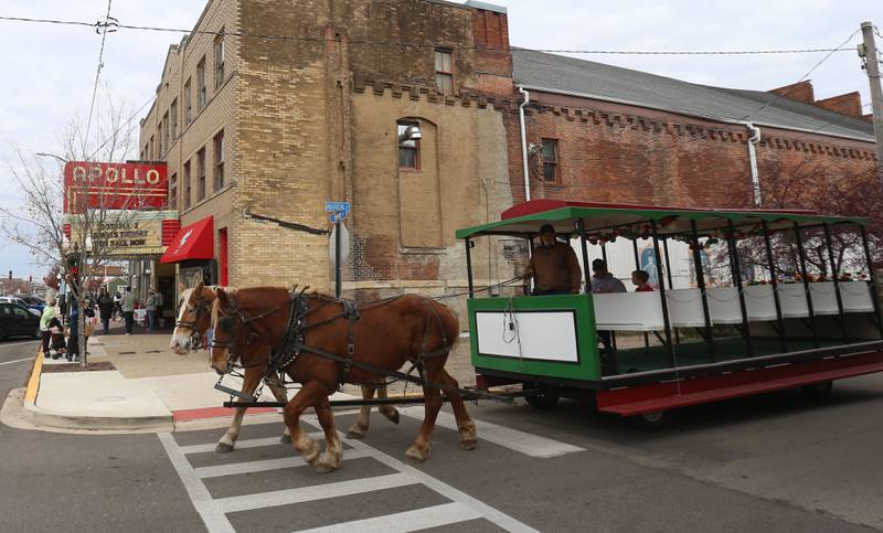 A team of horses pull a group of people in front of the Apollo Theater during the annual Christmas Walk on Saturday, Nov. 22, 2025 in Princeton.