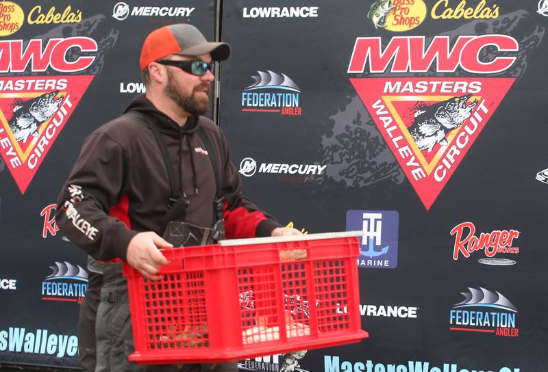 J.J. Debernardi of Wayne, takes his basket of fish to the Illinois Department of Natural Resources that he caught during the annual Masters Walleye Circuit tournament on Friday, March 21, 2025 at the Spring Valley Boat Club.