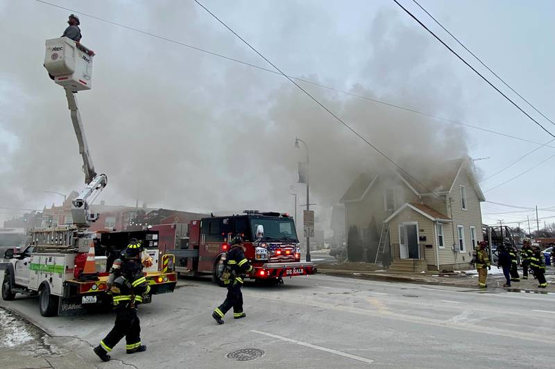 DeKalb firefighters walk toward a two-story duplex to help the emergency response on Saturday, Jan. 24, 2026, at Seventh Street and East Lincoln Highway downtown.