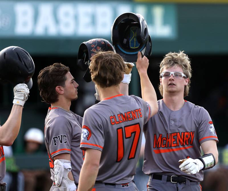 McHenry's Kaden Wasniewski high fives his teammates after he hit a two-run home run during a Fox Valley Conference baseball game against Crystal Lake South on Monday, April 13, 2026, at Crystal Lake South High School.