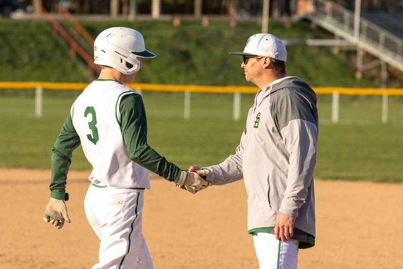 Carson Riva (3) of St. Bede greets first base coach on Tuesday, April 15, 2025 at St. Bede Academy in Peru.