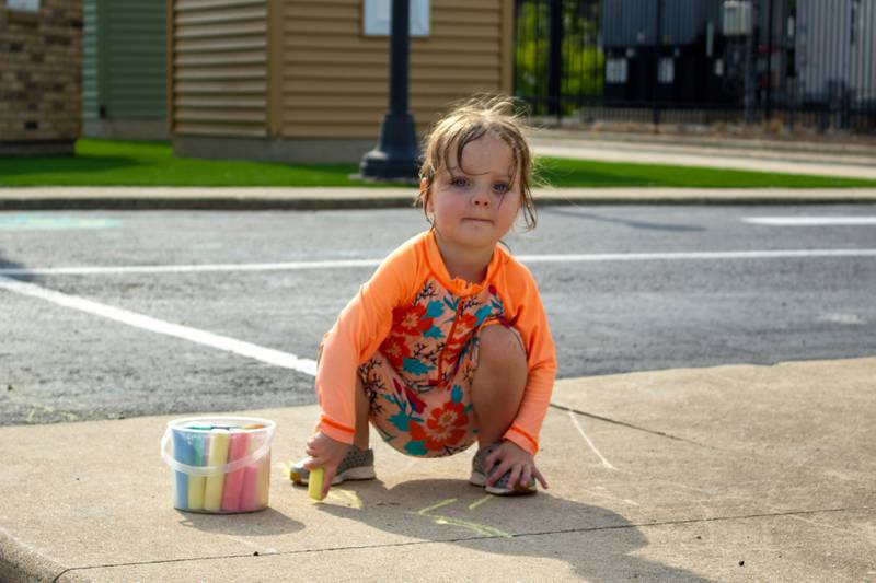 Adeline D'Agostino, 2, of Chicago, draws on the sidewalk with chalk during the 5th annual Bourbonnais Food Truck Festival on Saturday, Aug. 16, 2025.
