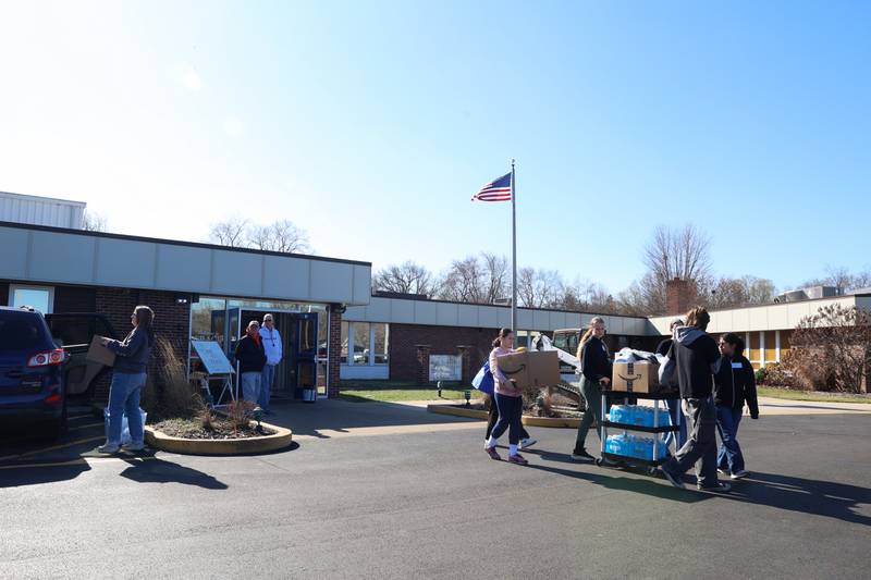 Volunteers help local residents bring supplies to their vehicles at Grace Christian Academy on Thursday, March 12, 2026, following the EF-3 tornado that tore through Kankakee County on March 10. The school, which is on the outskirts of Aroma Township along Waldron Road, canceled classes in order to become a supply and meal hub for those impacted by the storm.