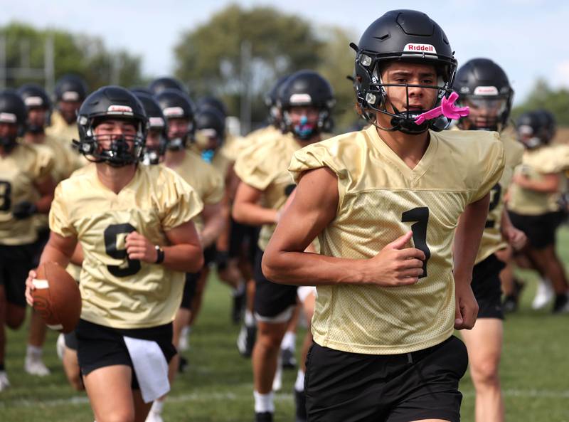 Sycamore’s Josiah Mitchell leads his team around the field as they get loose Monday, Aug. 11, 2025, at the start of their first fall practice at the school.