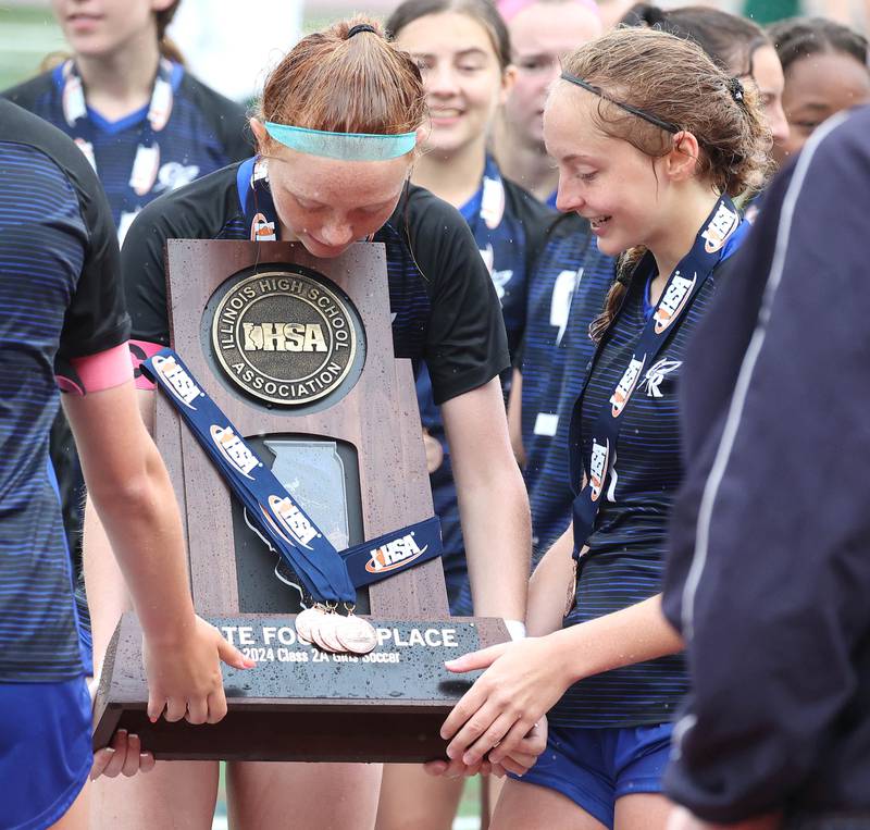 Burlington Central players admire the state fourth place trophy Saturday, June 1, 2024, after their consolation match loss to Peoria Notre Dame at the IHSA Class 2A state soccer finals at North Central College in Naperville.