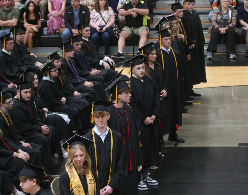 Putnam County High School graduates stand to receive their diplomas during the 59th annual Commencement on Sunday, May 18, 2025 in R.M. Germano gymnasium.