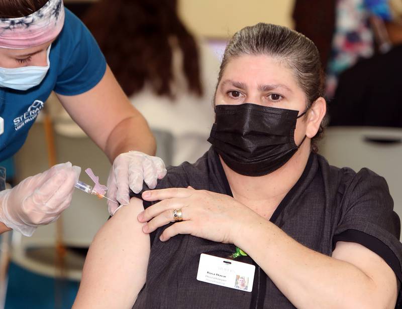 Timbers of Shorewood staff member Rosa Navar receives the flu and COVID-19 vaccines during a vaccine clinic held at Timbers of Shorewood Friday, October 8, 2021, in Shorewood, Ill.