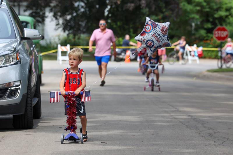 Quinn Cooke, 3, of Kankakee, makes his way to the finish line of the Kids' Bike Ride on his decorated scooter during the Riverview Historic District's annual 4th of July Celebration on Friday, July 4, 2025.
