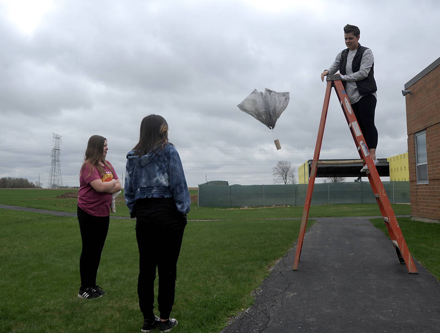 Students watch as STEM teacher Bethany Bellavia tests a students parachute during a Flight and Space STEM class at the school on Tuesday, April 26, 2022.